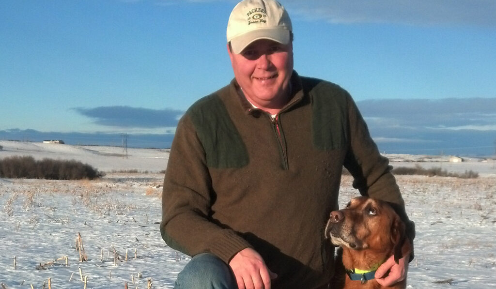 Jeff Essler with his dog out in a field hunting